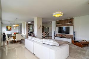 sala de estar con sofá blanco y comedor en Casa à beira-mar com piscina Floripa-SC RJD156 en Florianópolis