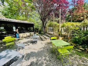 eine Terrasse mit einem grünen Tisch und Stühlen in der Unterkunft CAMPING LA PIBOLA in Camon