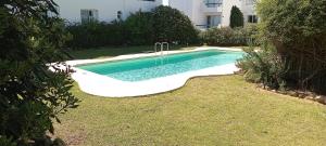 a swimming pool in a yard next to a building at Monoambiente in Punta del Este