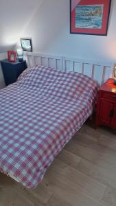 a bed with a red and white blanket on it at Chambre en duplex proche mer in Saint-Nazaire