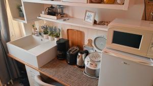 a small kitchen with a sink and a microwave at Chambre en duplex proche mer in Saint-Nazaire