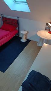 a living room with a red couch and a table at Chambre en duplex proche mer in Saint-Nazaire