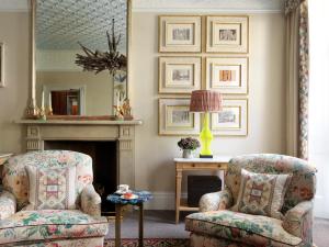 a living room with two chairs and a fireplace at Number Sixteen, Firmdale Hotels in London