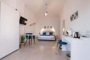 Cette chambre comprend un lit et une cuisine avec des tabourets. dans l'établissement B&B Jolie Suite, à Villasimius