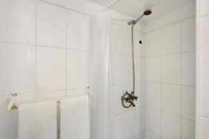 La salle de bains blanche est pourvue d'une douche et de serviettes blanches. dans l'établissement Casa con jardin, à Tacoronte 14 autres photos