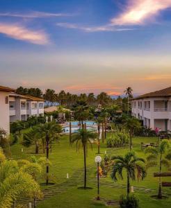 a view of a park with palm trees and buildings at Apartamento Térreo 3 suítes Master Resort Treebies à Beira Mar Subauma Bahia in Subaúma