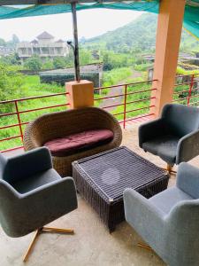 een patio met stoelen, een tafel en een parasol bij Palmquist Villa in Neral