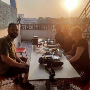 eine Gruppe von Menschen, die mit einer Kamera an einem Tisch sitzen in der Unterkunft S A HAVELI GUEST HOUSE in Bikaner