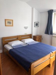 a bedroom with a large bed with a blue blanket at Stan u samom centru Obrenovca, na Trgu 2 in Obrenovac