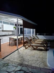 um pátio com cadeiras, uma mesa e uma cozinha em JVG VILLAS - Villa Joval em Güimar