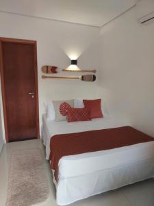 sypialnia z dużym białym łóżkiem z czerwonymi poduszkami w obiekcie Sea Paradise Hospedagem w mieście Fernando de Noronha