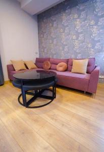 sala de estar con sofá púrpura y mesa en Park Avenue Hotel Yerevan, en Ereván