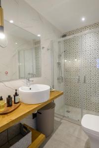 a white bathroom with a sink and a shower at Pelagia's Apartments Finikounda in Finikounta