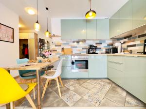 a kitchen with blue cabinets and a table and chairs at Corvin City Apartment - FREE PARKING- in Budapest