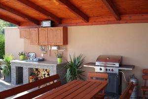 an outdoor kitchen with a table and a stove at Eplényi Apartmanház in Eplény