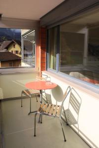 une table et deux chaises assises sur un balcon dans l'établissement Apartment 302 - Zentrales Studio, à Engelberg