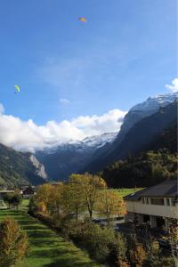 a kite is flying over a valley with mountains at Apartment 302 - Zentrales Studio in Engelberg