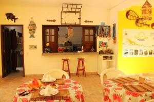 a living room with two tables and a kitchen at Pousada Pura Vida in Barreirinhas