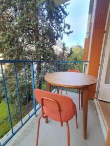 een tafel en een stoel op een balkon bij Château 5 min avec balcon et un Stationnement gratuit in Versailles