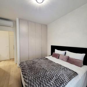 1 dormitorio con 1 cama grande con almohadas moradas en ForS Belgrade Waterfront, en Belgrado