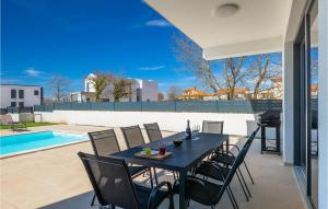 - une table à manger et des chaises sur une terrasse avec piscine dans l'établissement Villa Elena Rovinj, à Rovinj