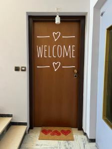 a brown door with a welcome sign on it at La nostra casa la vostra casa Cir00023 in Saint Vincent