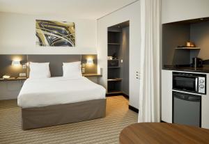 une chambre d'hôtel avec un lit et une cuisine dans l'établissement B&B HOTEL Rueil-Malmaison Gare, à Rueil-Malmaison 23 autres photos