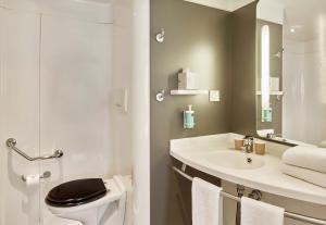 a bathroom with a sink and a toilet and a mirror at B&B HOME Rueil-Malmaison Gare in Rueil-Malmaison +29 photos
