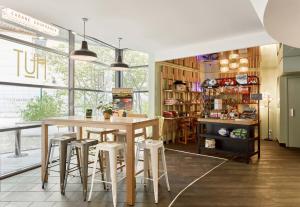 - une salle à manger avec une table et des tabourets dans l'établissement B&B HOTEL Rueil-Malmaison Gare, à Rueil-Malmaison