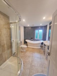 ein Bad mit einer Badewanne, einem WC und einer Dusche in der Unterkunft The Bridge House, Dunbar in Dunbar