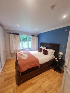 1 dormitorio con 1 cama grande y pared azul en The Bridge House, Dunbar, en Dunbar