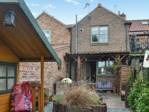 a brick house with an awning over a patio at Second Cottage in Cottingham