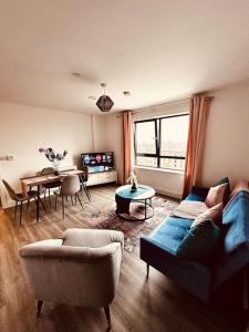 a living room with a couch and a table at BRAND NEW 5 STAR LUXURY 2 BEDROOM APARTMENT, SLEEPS 6, CENTRAL, WiFI, BIG SMART TV, ALEXA SPEAKERS, EASY ACCESS LOCK BOX ENTRY! NO PARTIES! in Liverpool