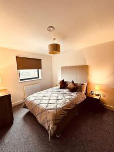 a bedroom with a bed with two cats laying on it at BRAND NEW 5 STAR LUXURY 2 BEDROOM APARTMENT, SLEEPS 6, CENTRAL, WiFI, BIG SMART TV, ALEXA SPEAKERS, EASY ACCESS LOCK BOX ENTRY! in Liverpool