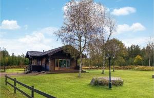 a small wooden cabin in a field with a fence at 2 Bedroom Awesome Home In Rishult in Rishult