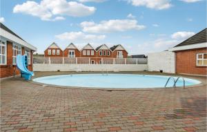 a swimming pool with a blue slide in a courtyard at Lejlighed 28 in Rømø Kirkeby