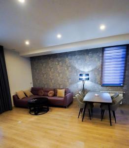 - un salon avec un canapé et une table dans l'établissement Park Avenue Hotel Yerevan, à Erevan