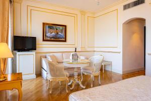 a living room with a table and a couch at Hotel Astoria in Stresa