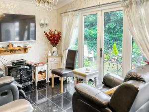 a living room with a couch and a table and chairs at Hollyhocks Bungalow - Uk39617 in Welcombe