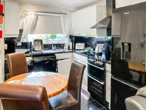 a kitchen with a wooden table in the middle at Hollyhocks Bungalow - Uk39617 in Welcombe