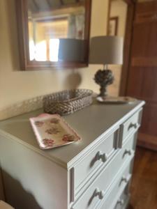 a white dresser with a lamp on top of it at Pond Cottage in Egerton