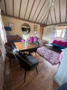 a living room with a table and a couch at Pond Cottage in Egerton