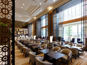 a dining room with tables and chairs and large windows at Hotel The Celestine Tokyo Shiba in Tokyo