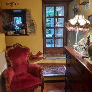 een woonkamer met een stoel en een raam bij La Casa della Piazzetta in Fanano