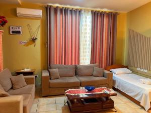 a living room with a couch and a bed at Jessie's apartments in Durrës
