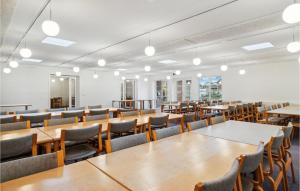 una sala da pranzo con tavoli, sedie e luci di Lejlighed 119 a Rømø Kirkeby