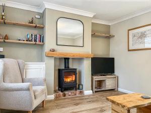 a living room with a fireplace and a television at The Snug in Southwell