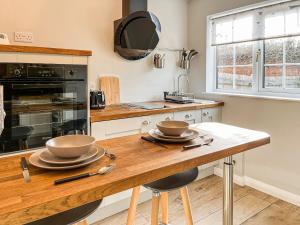 a kitchen with a wooden table with two bowls on it at The Snug in Southwell