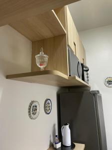eine Küche mit einem Regal über einem Kühlschrank in der Unterkunft The best ap in Rio de Janeiro