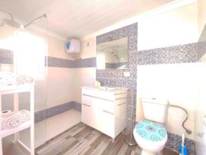 een badkamer met een toilet, een wastafel en een spiegel bij Eolo OceanFront in Telde